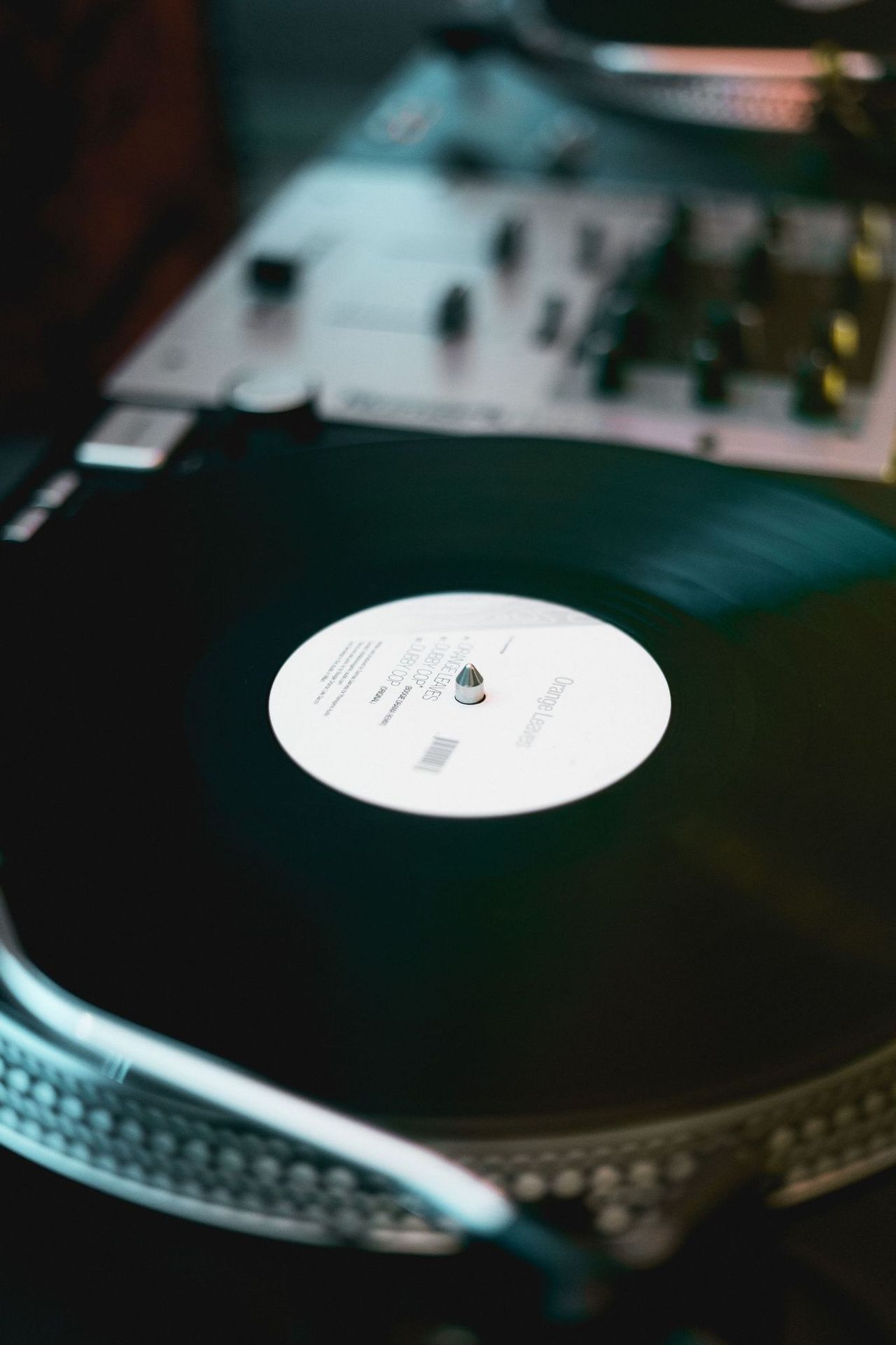A turntable spinning a black vinyl record on a wooden surface