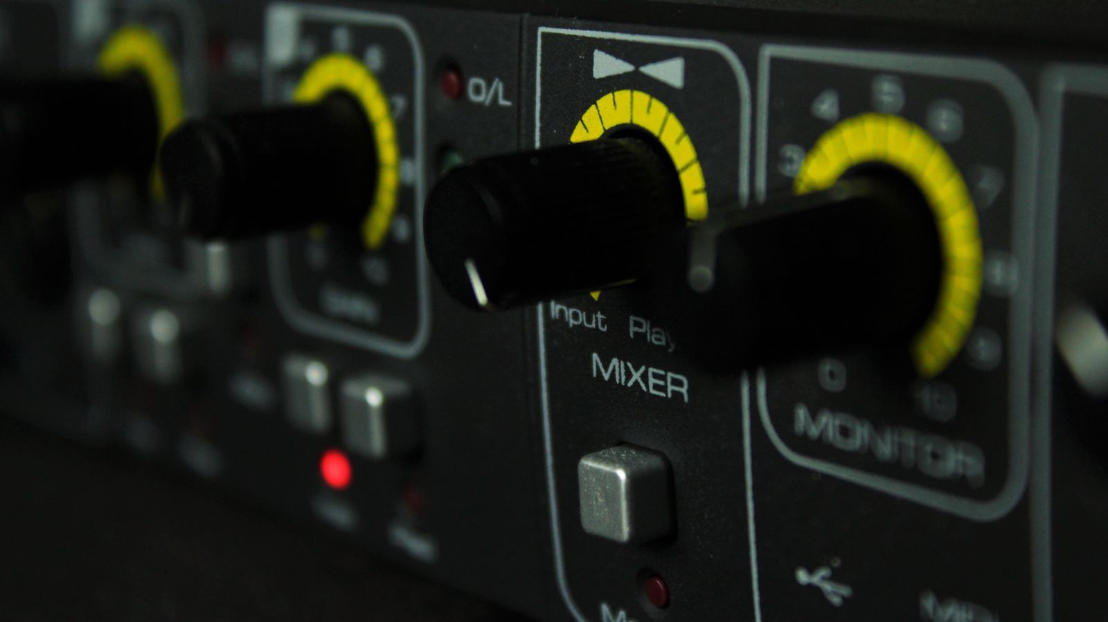 Close-up of black knobs with yellow rings on an audio interface rack unit